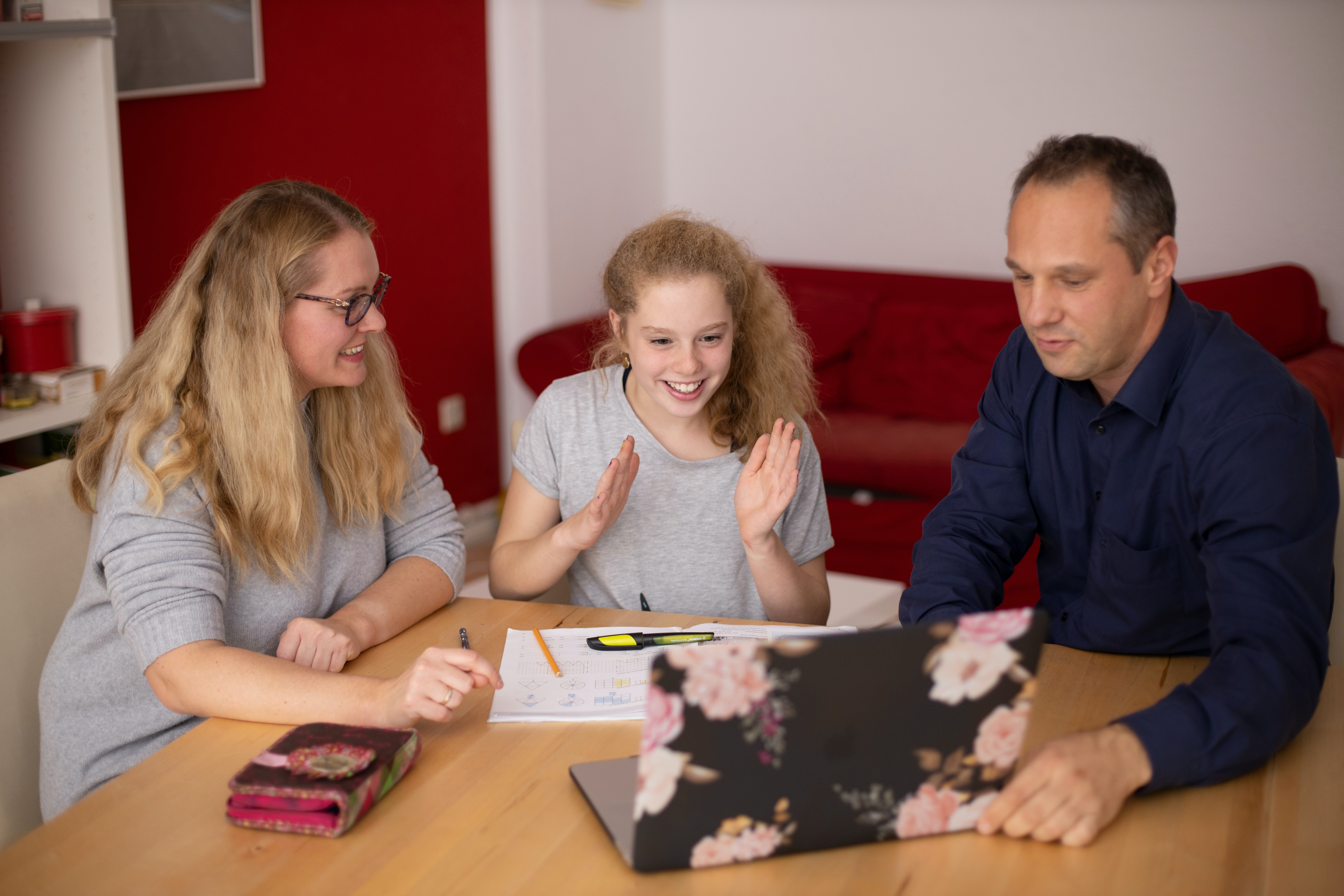 Two adults helping a student study at a table