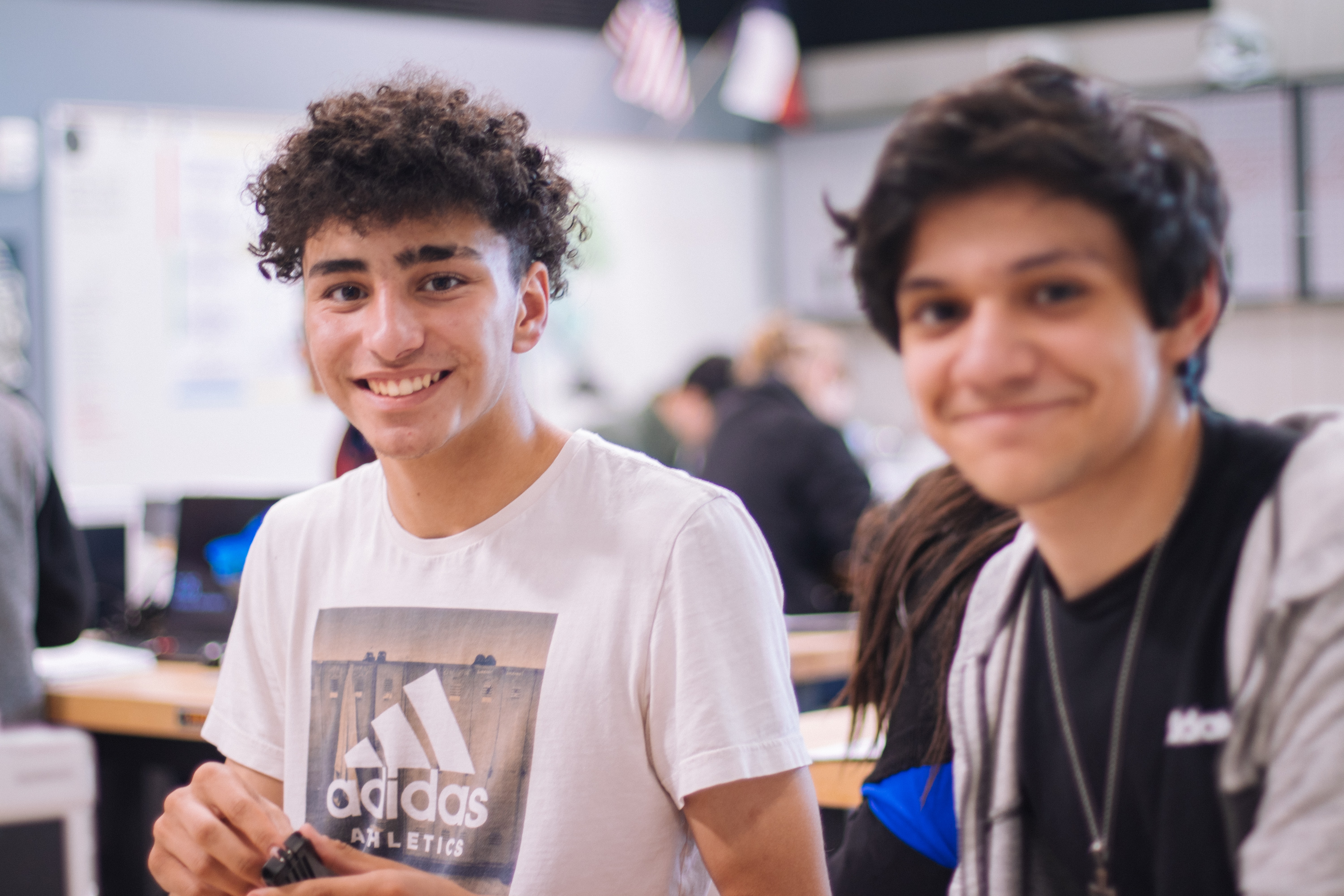 Two young men smiling in a school classroom