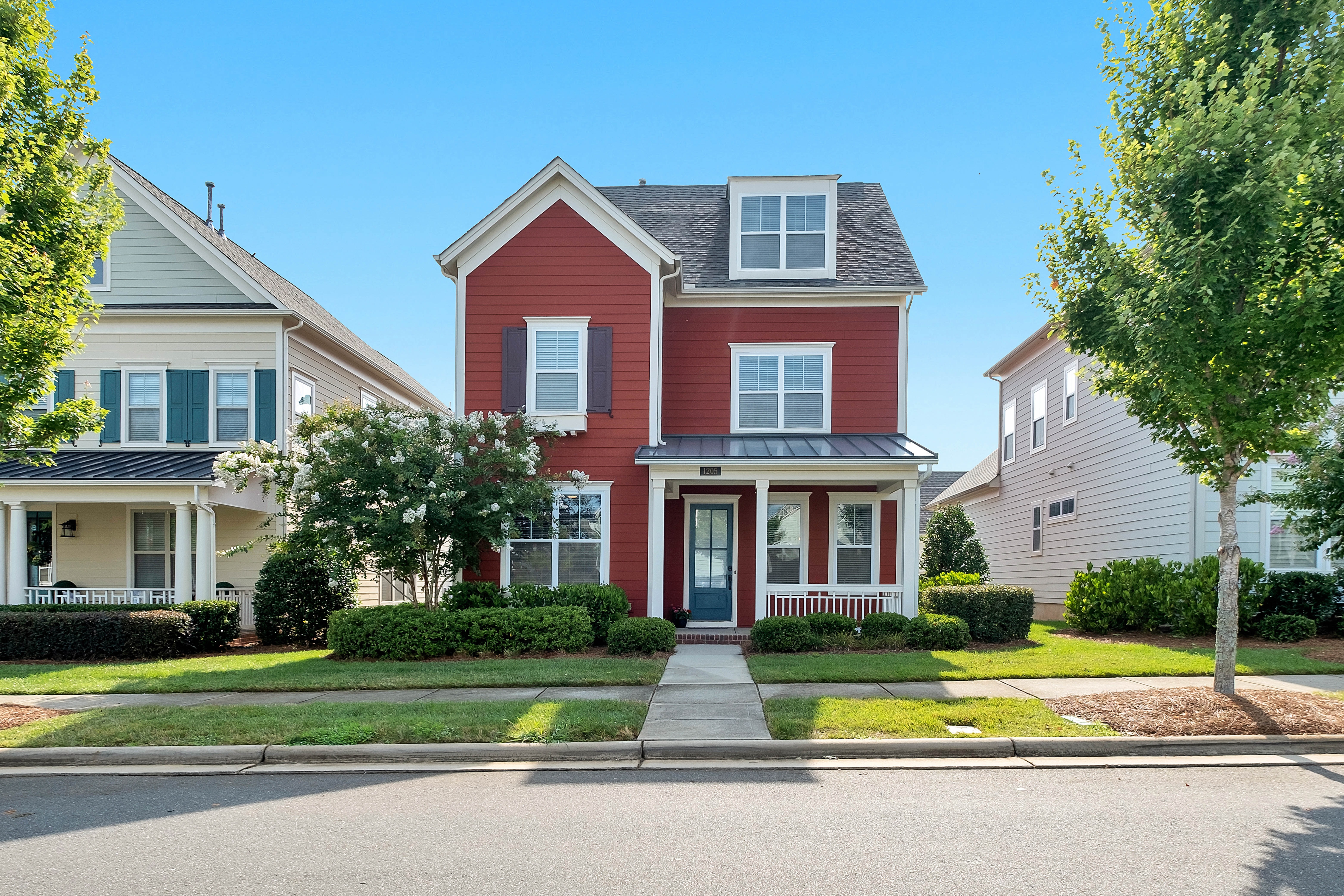 Two story house with red siding and small covered porch