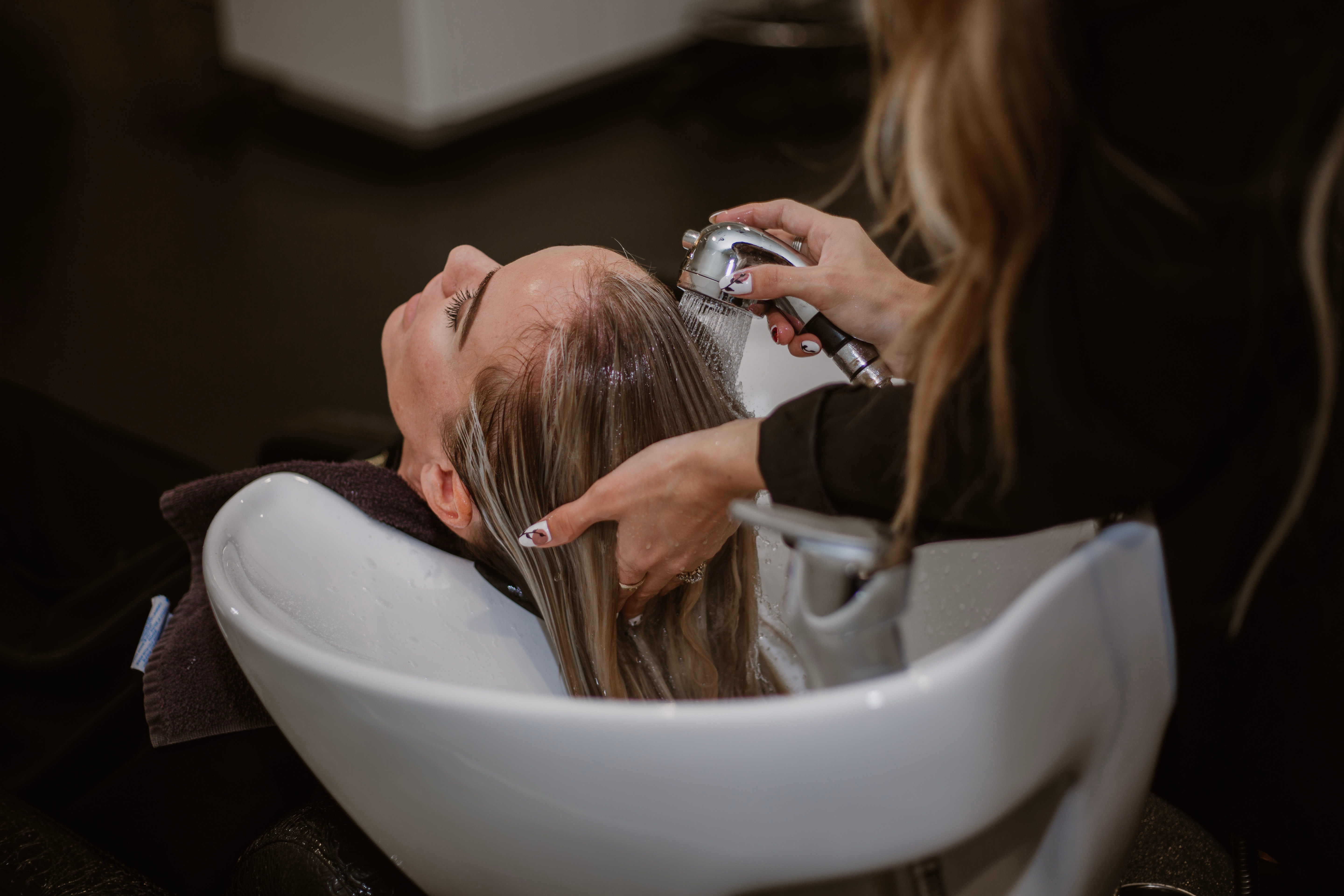 A female client having her hair washed at a beauty salon