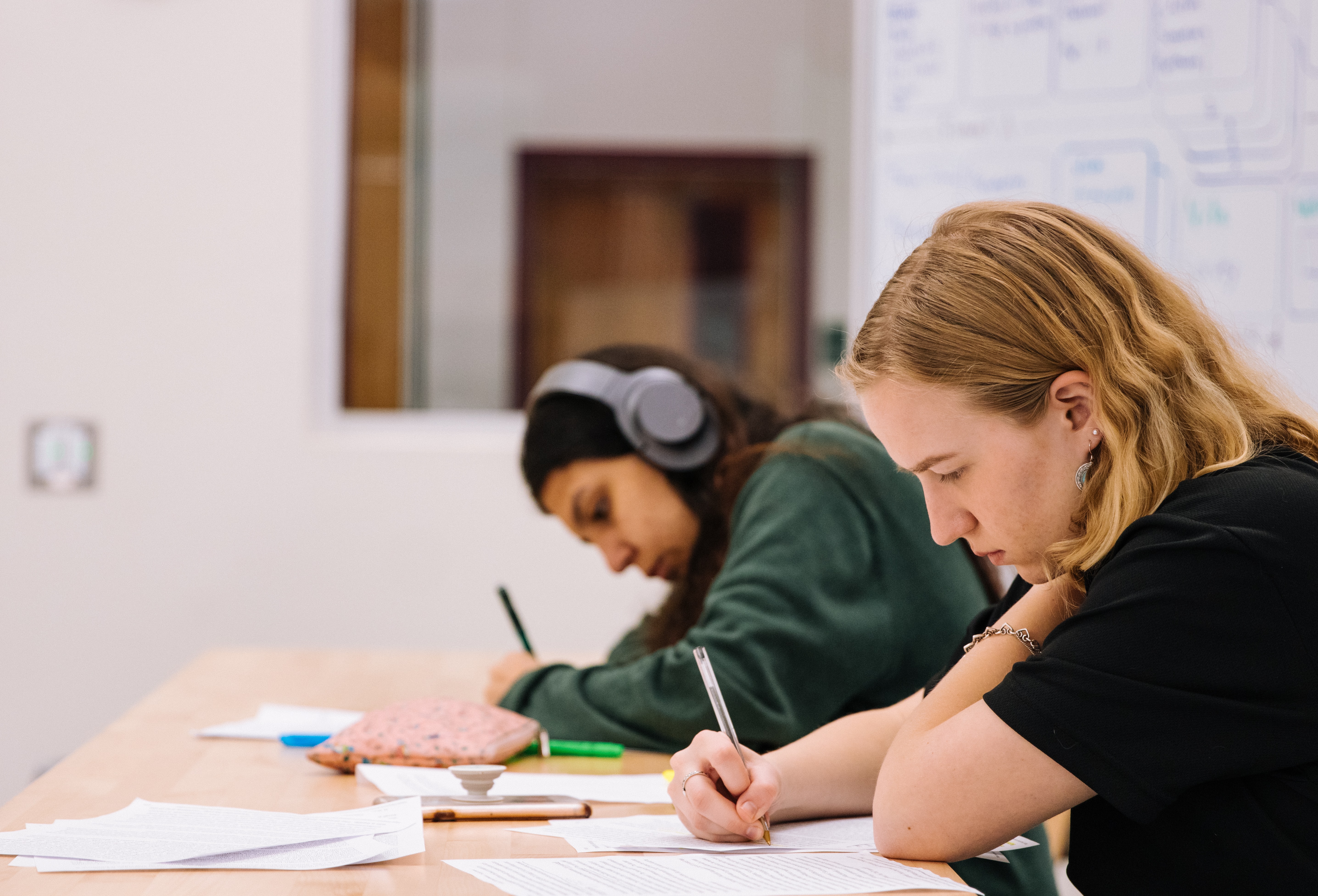 Two students studying for an exam at a table in school