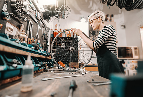 Woman Mechanic truing a bike wheel on a bench