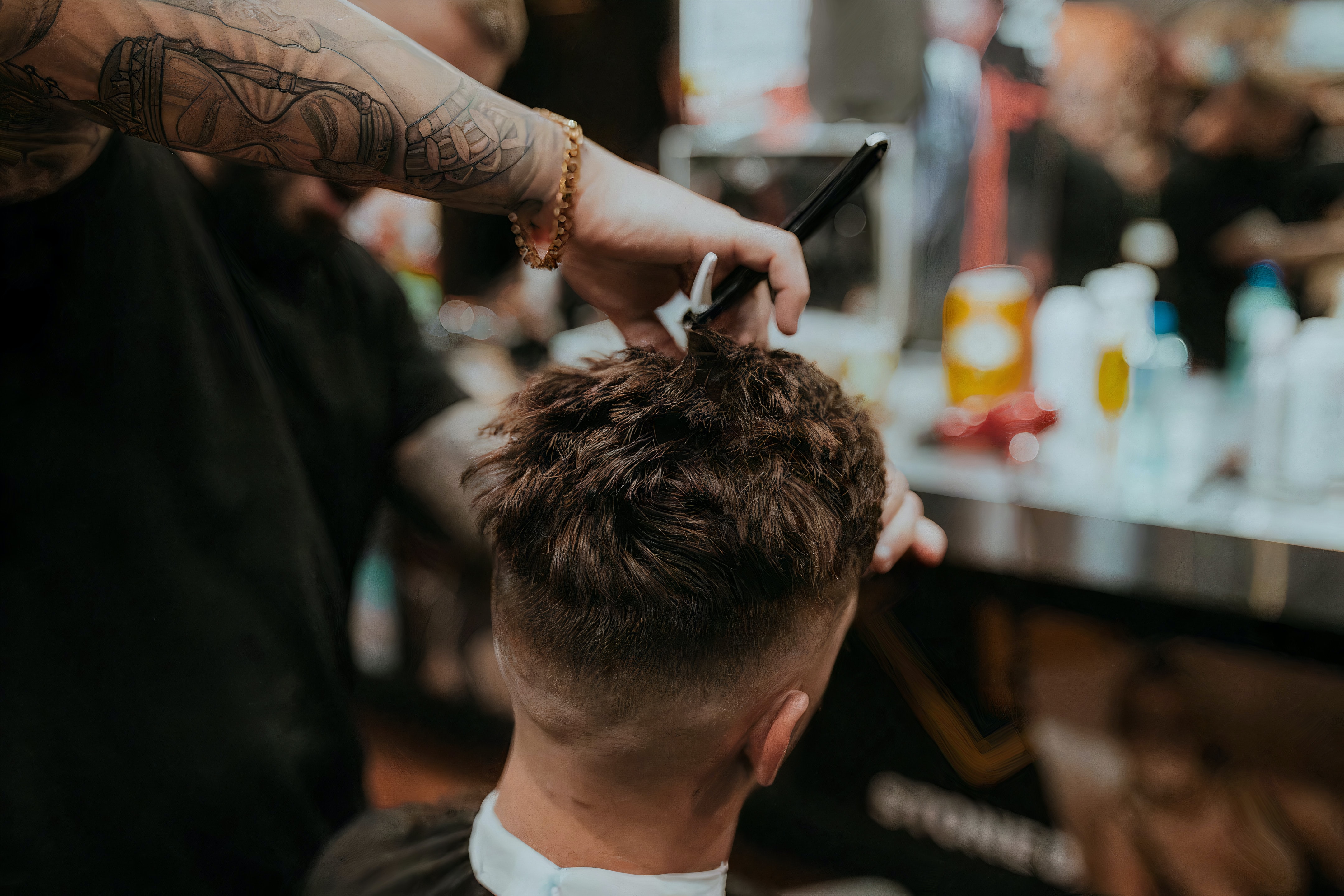 A male client getting his hair cut and styled at a salon